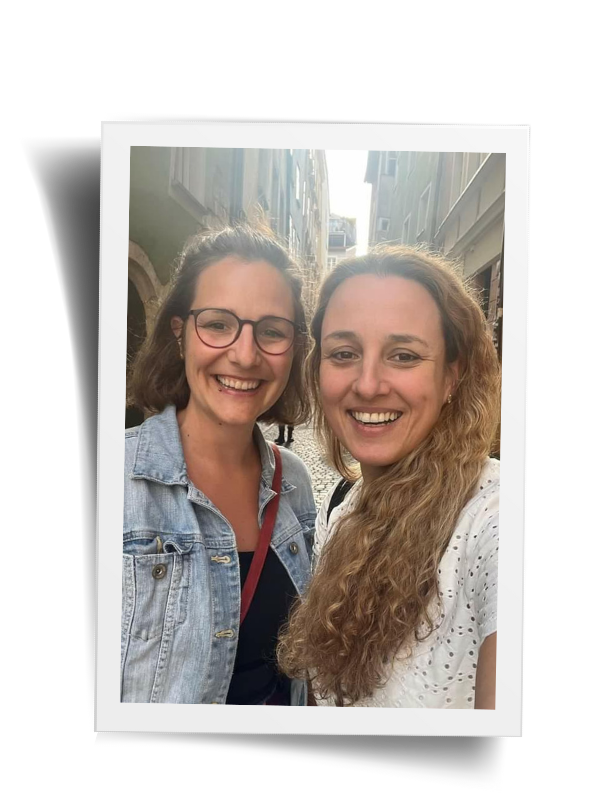 Celi Selfie von zwei lächelnden Frauen im Hintergrund eine schmale Strasse der Regensburger Altstadt.